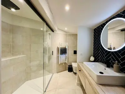 a bathroom with a sink and a shower and a mirror at Le Moulin de La Grave 450m2 in Lagrasse