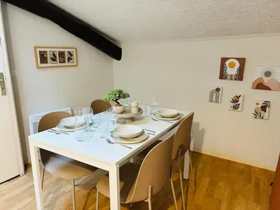a dining room table with chairs and a white table and chairsktop at Appartement Proche Place Soult l 2 CH in Castres