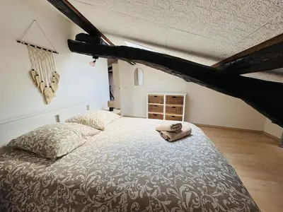 a bedroom with a bed with a pillow and a hat on it at Appartement Proche Place Soult l 2 CH in Castres