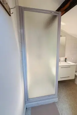 a sliding glass door in a bathroom with a sink at Appartement Proche Place Soult l 2 CH in Castres