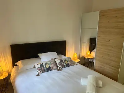 a bedroom with a large white bed with two lamps at Aux 138 bis in Carcassonne