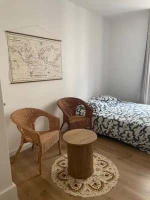 a bedroom with a bed and two chairs and a table at Le Mi-Stud in Castres