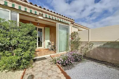 a house with a porch with flowers in front of it at La Dali - Maison de vacance proche de la mer in Sigean