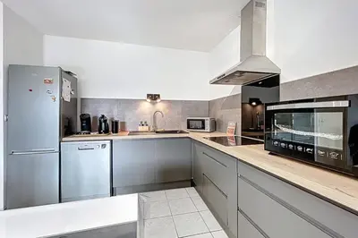 a kitchen with a refrigerator and a stove top oven at La Dali - Maison de vacance proche de la mer in Sigean
