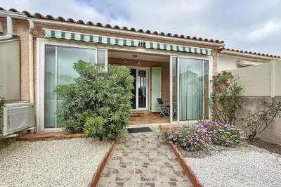 a home with a large glass door and a patio at La Dali - Maison de vacance proche de la mer in Sigean