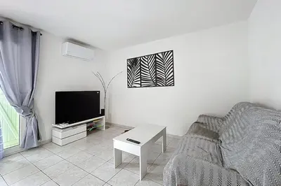a living room with a couch and a tv at La Dali - Maison de vacance proche de la mer in Sigean