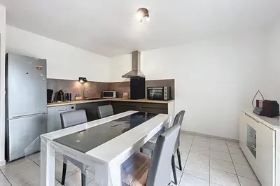 a kitchen with a table and chairs in a kitchen at La Dali - Maison de vacance proche de la mer in Sigean