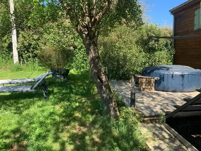 a tree and a tub sitting next to a house at Roulotte et Nature in Mirepoix