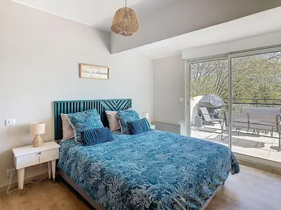 a bedroom with a bed with a blue comforter at La terrasse du Canal, appartement pour 5 personnes in La Redorte