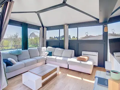 a living room with a white couch and some windows at La terrasse du Canal, appartement pour 5 personnes in La Redorte