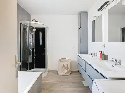 a white bathroom with two sinks and a shower at La terrasse du Canal, appartement pour 5 personnes in La Redorte