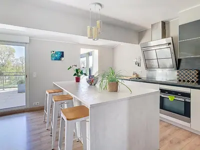 a kitchen with a large kitchen island with stools at La terrasse du Canal, appartement pour 5 personnes in La Redorte