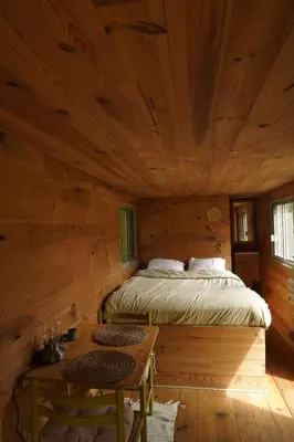 a bedroom with a bed in a log cabin at Roulotte pour amoureux de la nature in Bugarach