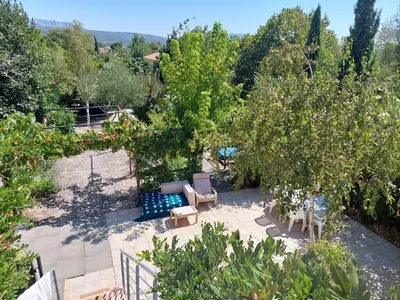 a garden with chairs and an apple tree at Chambre d'hôte Les Maisons de Gaïa in Tuchan