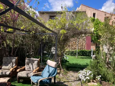 a garden with two chairs and a gazebo at Chambre d'hôte Les Maisons de Gaïa in Tuchan