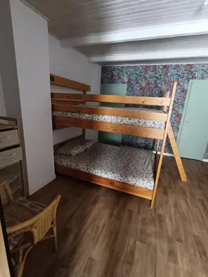 a room with two bunk beds and a chair at Chambre d'hôte Les Maisons de Gaïa in Tuchan