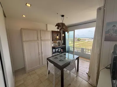 a dining room with a table and a large window at Appartement 2 pièces Port la Nouvelle PN430-026 in Port-la-Nouvelle