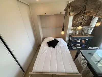 a small room with a white bed with a black pillow at Appartement 2 pièces Port la Nouvelle PN430-026 in Port-la-Nouvelle