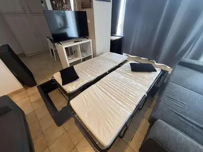a room with two beds and a flat screen tv at Appartement 2 pièces Port la Nouvelle PN430-026 in Port-la-Nouvelle