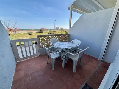 a patio with a table and chairs on a balcony at Appartement 2 pièces PORT LA NOUVELLE PN430-030 in Port-la-Nouvelle