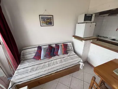 a room with a bed with four pillows on it at Appartement 2 pièces PORT LA NOUVELLE PN430-030 in Port-la-Nouvelle