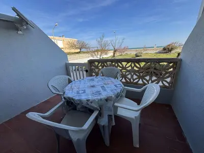 a lighthouse next to the ocean with a cruise ship at Appartement 2 pièces PORT LA NOUVELLE PN430-030 in Port-la-Nouvelle
