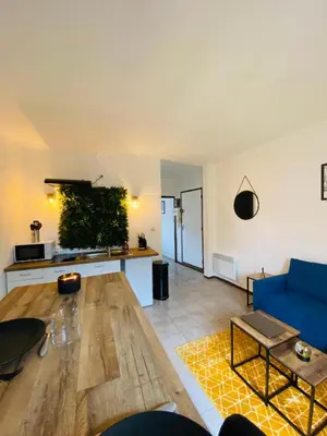 a living room with a blue couch and a table at Logement coeur de ville in Narbonne