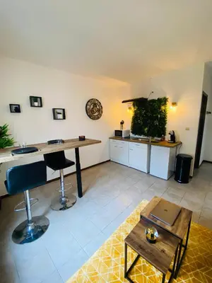 a living room with a table and a kitchen at Logement coeur de ville in Narbonne