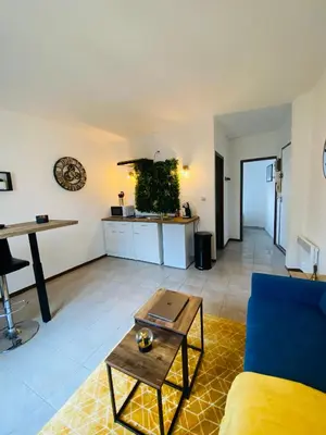 a living room with a blue couch and a table at Logement coeur de ville in Narbonne