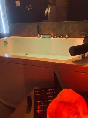 a bathroom with a bath tub with a sink at Love room Narbonnaise in Narbonne