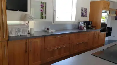 a kitchen with wooden cabinets and a black counter top at Villa Jade in Lasserre-de-Prouille