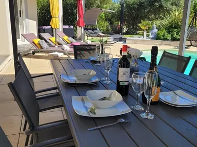 a blue table with wine bottles and glasses on it at Villa Jade in Lasserre-de-Prouille