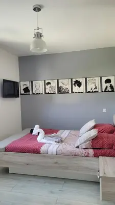 a bedroom with a bed with red sheets and white pillows at Villa Jade in Lasserre-de-Prouille