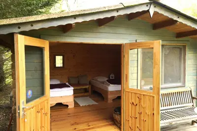 a large wooden house with a porch and a room at Jolie cabane avec vue magique sur la montagne in Bugarach