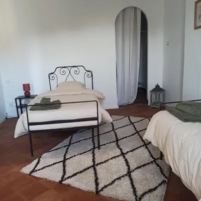 a bedroom with a bed and a rug at Le gîte des lavandiéres in Quarante