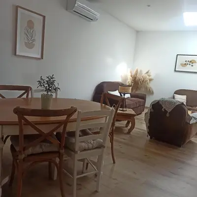 a living room with a wooden table and chairs at Le gîte des lavandiéres in Quarante