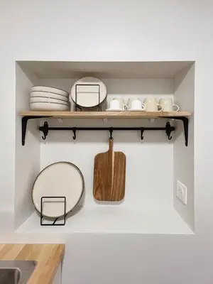 a kitchen shelf with plates and bowls on it at Japandi en centre-ville in Narbonne