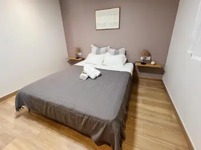 a bedroom with a large bed with two stuffed animals on it at Japandi en centre-ville in Narbonne