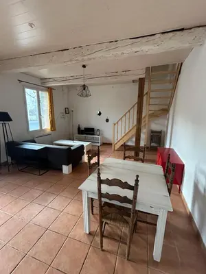 a living room with a table and a couch at La forge in Laroque-de-Fa