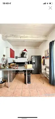 a kitchen with a table and a refrigerator at La forge in Laroque-de-Fa