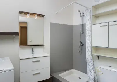 a white bathroom with a sink and a shower at Le refuge du canal Local à vélo Face canal du midi in Castelnaudary