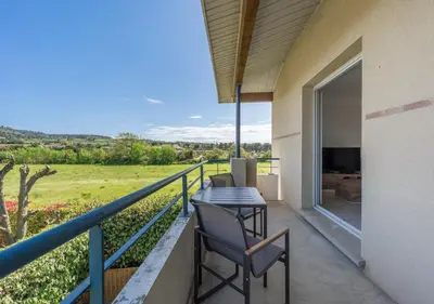 a balcony of a house with a table and chairs at Lumaïa - Vue cité, terrasse & Piscine in Carcassonne