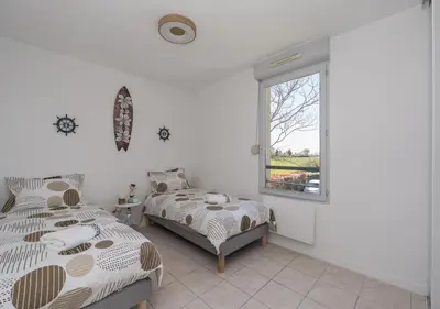 a bedroom with two beds and a window at Lumaïa - Vue cité, terrasse & Piscine in Carcassonne