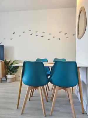 a table with four blue chairs in a room at Studio cabine climatisé magnifique vue port in Gruissan