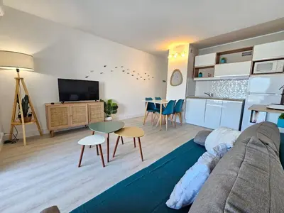 a living room with a couch and a table at Studio cabine climatisé magnifique vue port in Gruissan