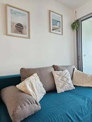 a blue couch with pillows on it in a room at Studio cabine climatisé magnifique vue port in Gruissan
