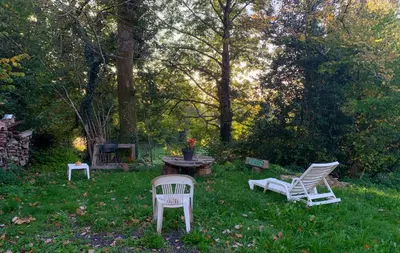 two chairs and a table in a yard at La petite maison dans le Sidobre in Fontrieu
