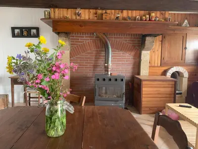 a vase of flowers on a wooden table in a kitchen at La petite maison dans le Sidobre in Fontrieu