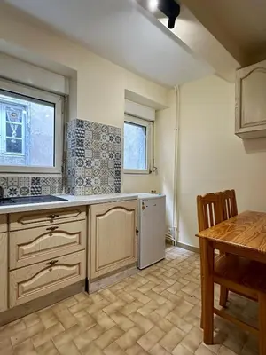 a kitchen with a sink and a dishwasher and a table at Charmant Appartement - 2 chambres - Carcassonne Centre in Carcassonne