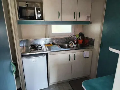 a small kitchen with a sink and a stove at Hébergement au Lac des Montagnès pour 5 personnes in Mazamet